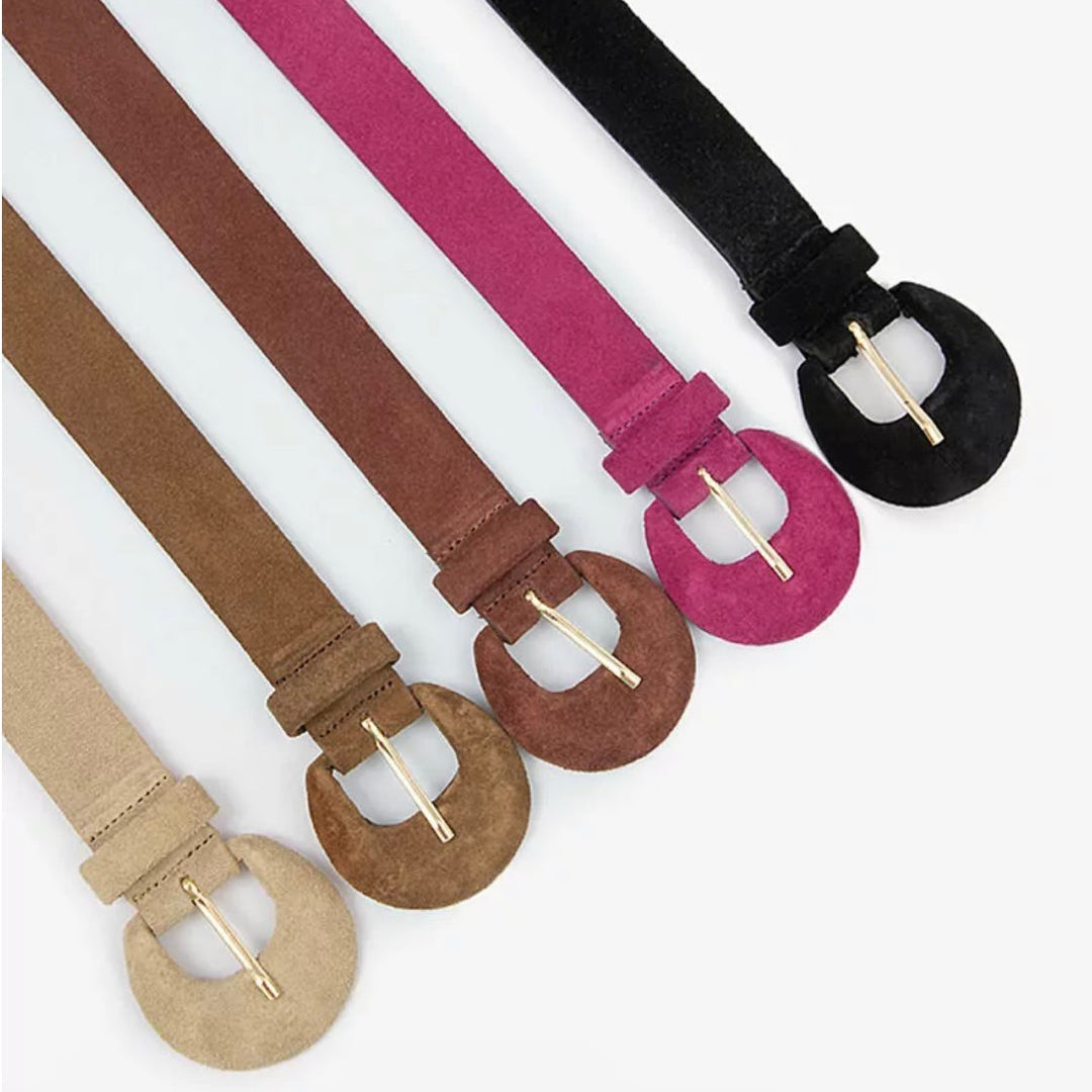 A collection of suede leather belts with half moon buckles, displayed in different colors.