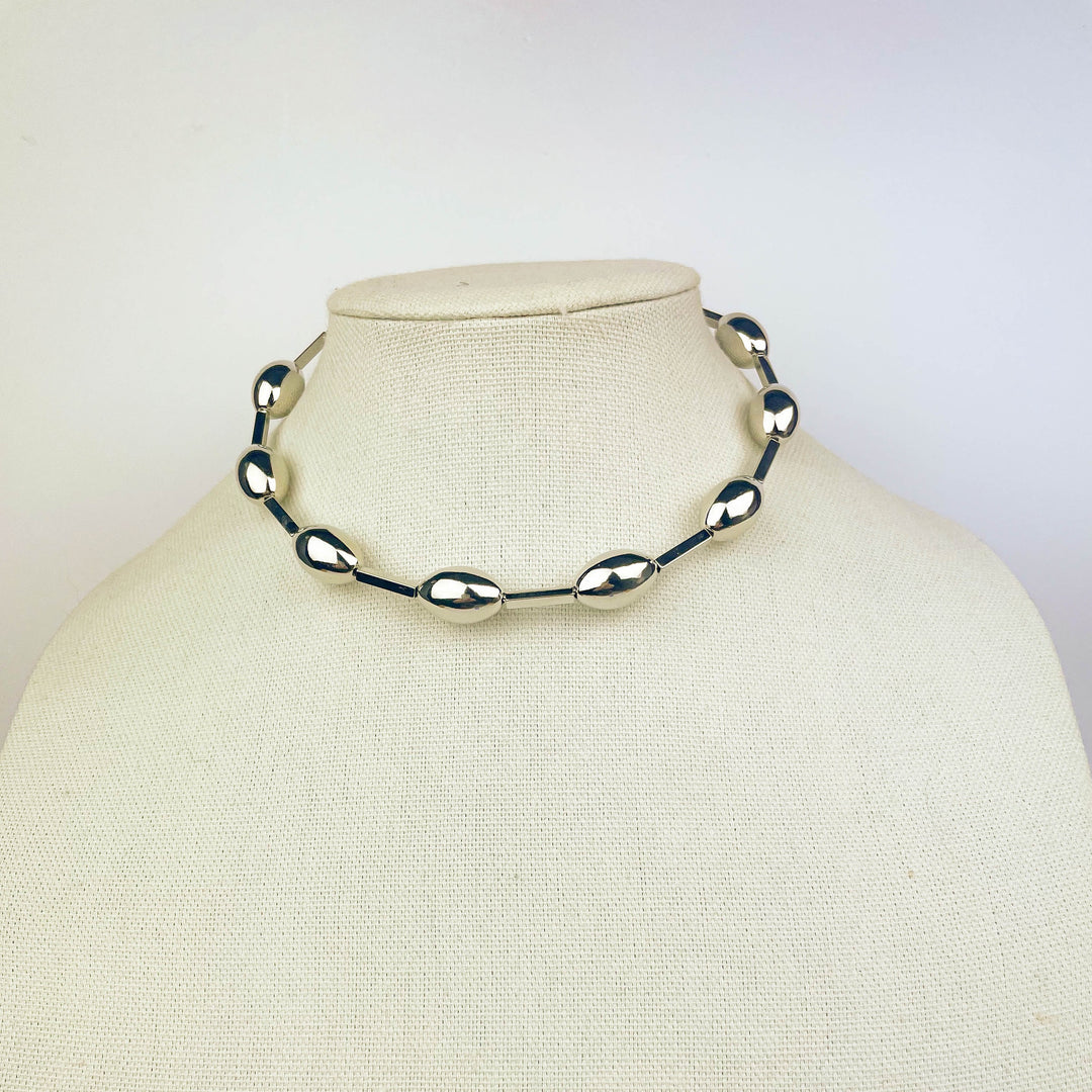Minimalist Sphere Choker with polished gold spheres and secure clasp on neckline