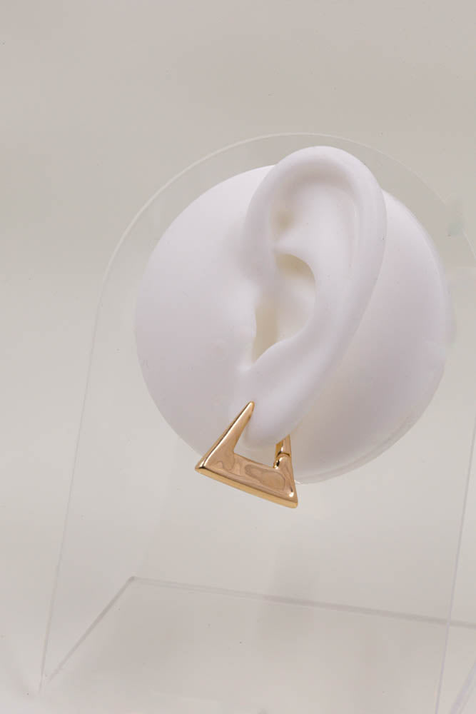 Modern triangle hoop earrings plated in 18k gold on clear wood display stand